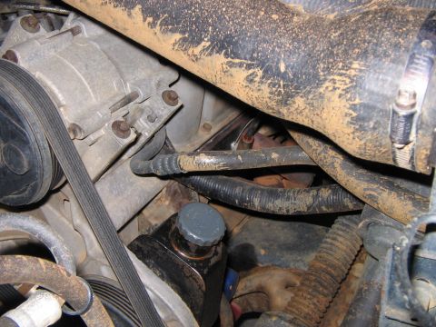 1992 Ford Bronco - Close-up of the engine bay in a 1992 Ford Bronco, highlighting the alternator and various hoses.