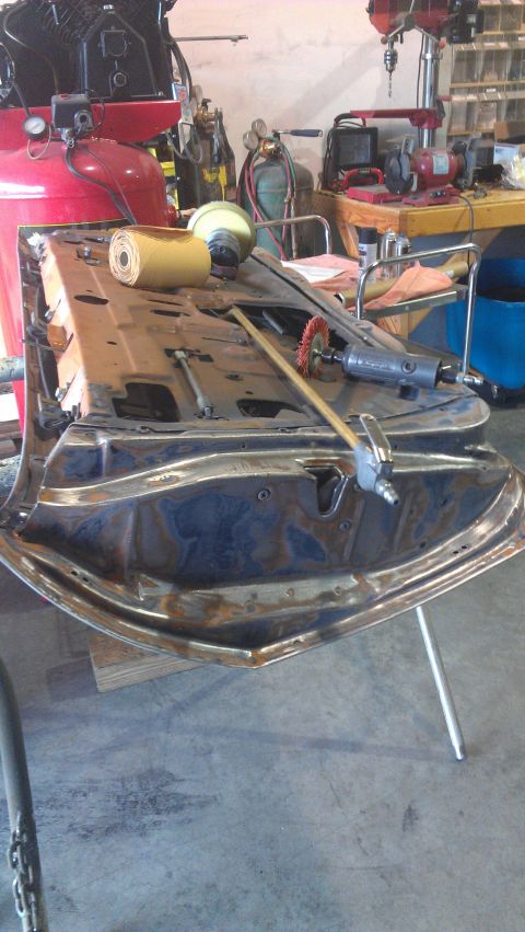 1973 Chevrolet Camaro - A car door frame is being worked on in a garage with various tools and equipment visible.