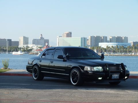 2003 Ford Crown Victoria - Murdered-out Crown Victoria with grille guard and black wheels overlooking the harbor and downtown skyline