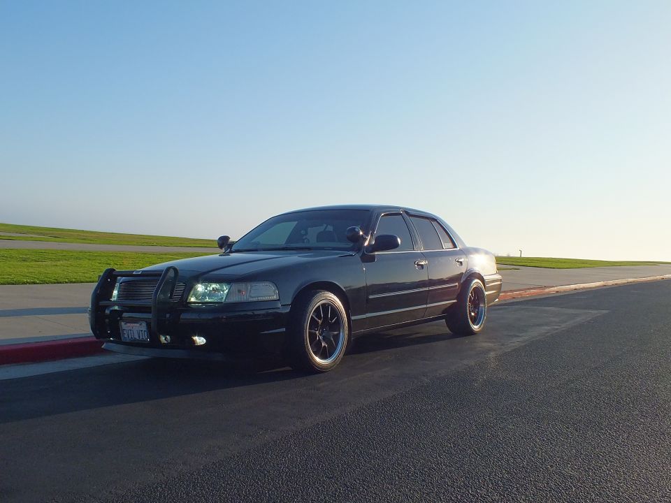 Black Crown Victoria front three-quarter with grille guard and CA plate at overlook