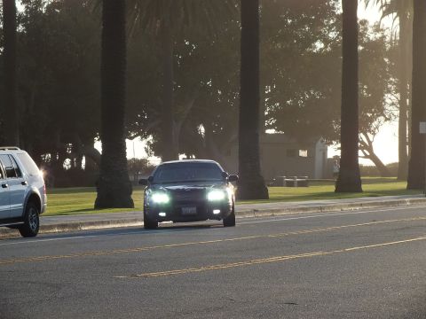 2003 Ford Crown Victoria - Oncoming black sedan with bright headlights, an SUV passing on the left.