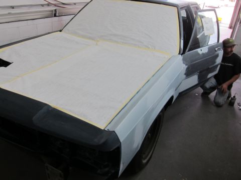 1991 Ford LTD Crown Victoria - A car is undergoing bodywork and preparation for painting, with a person working on the door.