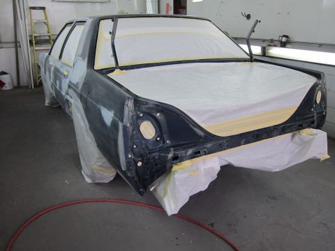 1991 Ford LTD Crown Victoria - A Ford Crown Victoria is covered in masking paper and plastic in a workshop, ready for bodywork.