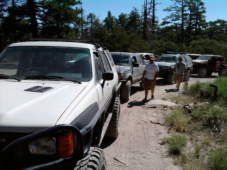 1985 Toyota 4Runner in foreground, followed by other off-road vehicles on a dirt path