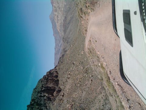 1985 Toyota 4Runner - A vehicle travels along a narrow dirt road with a sheer drop on one side.