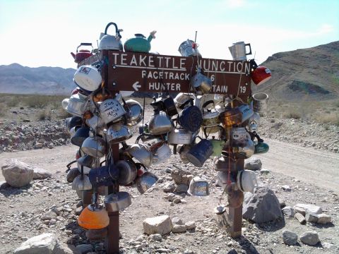 1985 Toyota 4Runner - A unique roadside attraction, Teakettle Junction, features a signpost adorned with numerous kettles in a remote desert setting.