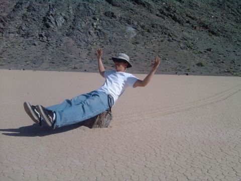 1985 Toyota 4Runner - A person poses on a rock in a vast, dry lakebed, with mountains in the background.