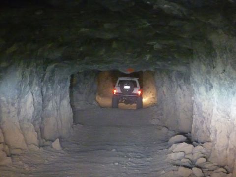 1985 Toyota 4Runner - SUV navigates a rough, unpaved tunnel with rough-hewn walls.