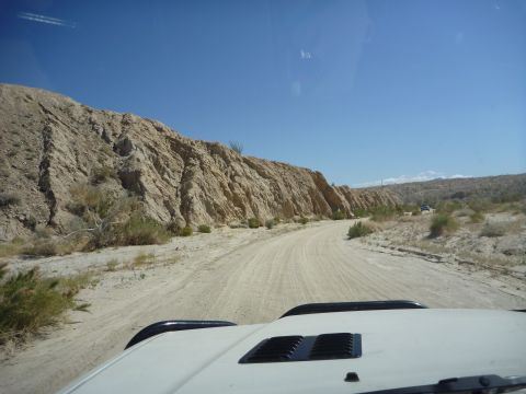 1985 Toyota 4Runner - Driving through a desert landscape on a dirt road, with a glimpse of another vehicle ahead.