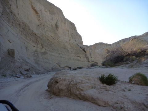 1985 Toyota 4Runner - A dirt road traverses a narrow desert canyon with towering rock formations and dry brush.