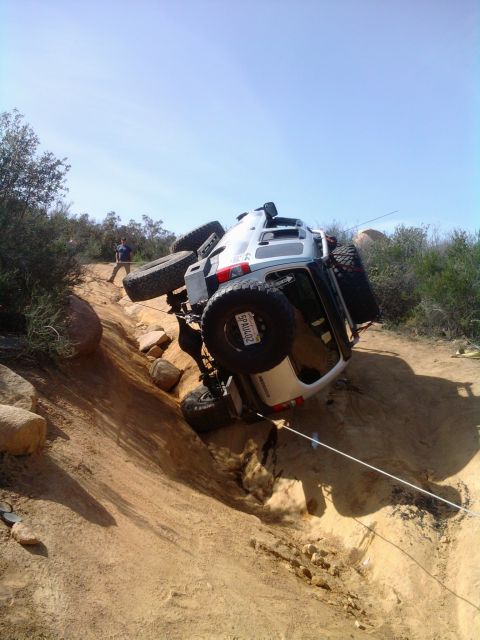 1985 Toyota 4Runner - An off-road SUV has rolled onto its side while navigating a steep, rocky incline.