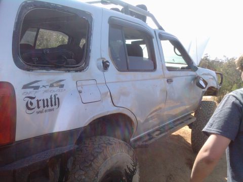 1985 Toyota 4Runner - Silver SUV with off-road modifications and missing rear window.