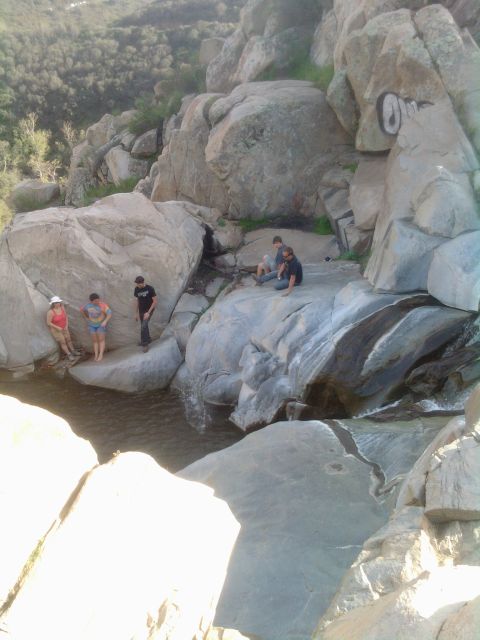 1985 Toyota 4Runner - Several people are gathered on rocks near a small waterfall in a , natural setting.