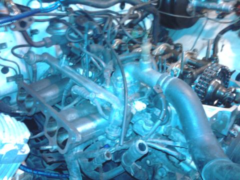 1985 Toyota 4Runner - Close-up view of an engine bay, showing various hoses, wiring, and mechanical components.
