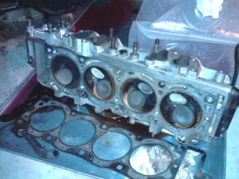 1985 Toyota 4Runner - Disassembled engine components, including a cylinder head and gasket, are visible in this close-up view.