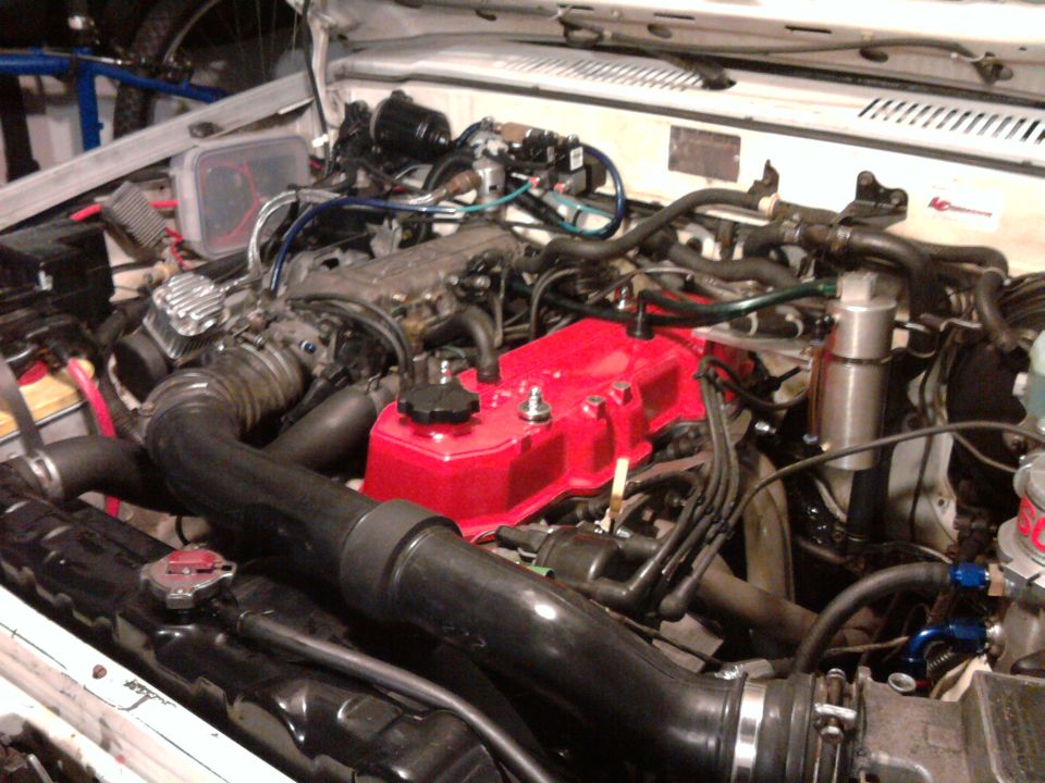 1985 Toyota 4Runner engine bay with red valve cover and black hoses