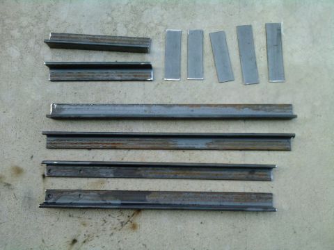 1985 Toyota 4Runner - Various metal components, including channel sections and flat plates, are arranged on a concrete surface.