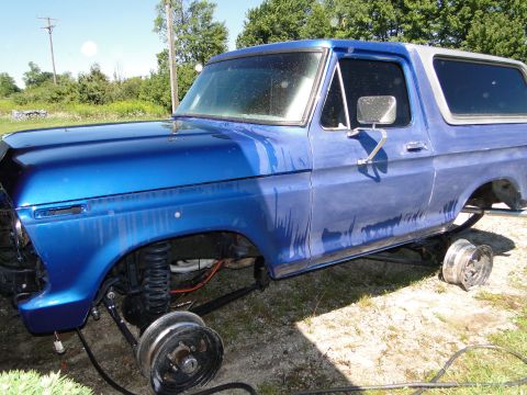 1978 Ford Bronco - A blue 1978 Ford Bronco sits without wheels, showing its body style and white hardtop.