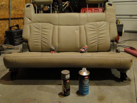 1978 Ford Bronco - Car seat and cleaning supplies are laid out on a garage floor.