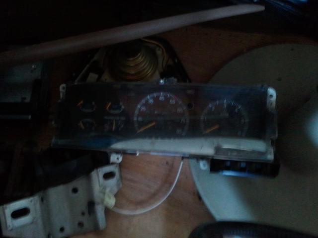 Dashboard gauges with speedometer and tachometer, some warning lights visible