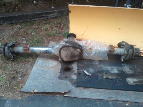 1993 Ford Bronco - A rear axle assembly is shown resting on a metal sheet outdoors.