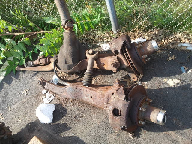 Rusty front axle and differential parts on the ground