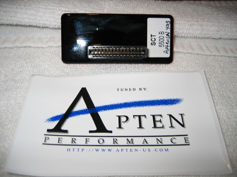 2002 Ford Taurus - A black SCT performance tuning chip with an exposed multi-pin edge connector sits on a white towel, hand-labeled 'SCT 5500 B Apten SN 4013'…