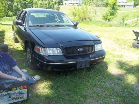2004 Ford Crown Victoria - Front view of a black 2004 Ford Crown Victoria parked on grass.