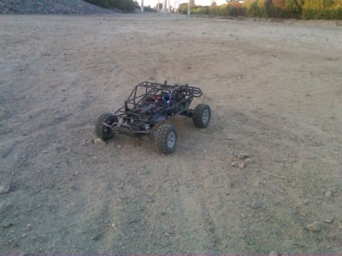 1986 Ford Bronco - A remote control buggy sits on a dirt track with a wooded area in the background.