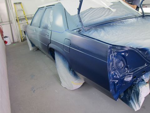 1991 Ford LTD Crown Victoria - A blue sedan is being prepped for painting, with plastic sheeting covering most of the vehicle.