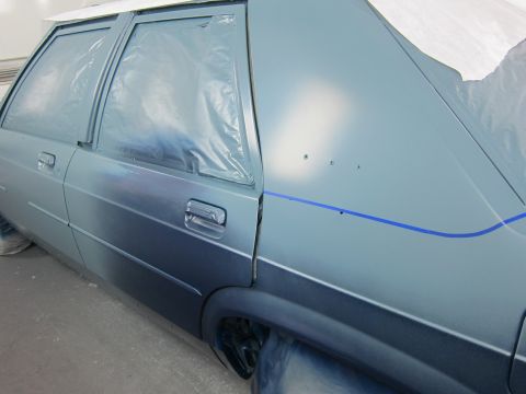 1991 Ford LTD Crown Victoria - Car body is taped off and being painted in a spray booth.