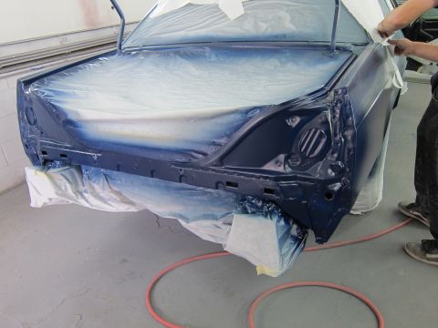 1991 Ford LTD Crown Victoria - A car is being prepped for painting in a workshop, with plastic sheeting covering most of the body.