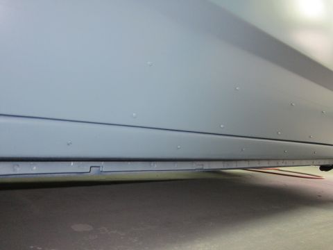 1991 Ford LTD Crown Victoria - Close-up view of the side panel of a light blue vehicle, highlighting rivets and a distinct horizontal body line.