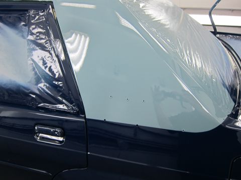 1991 Ford LTD Crown Victoria - Car body panels covered in plastic sheeting, possibly before a paint job.