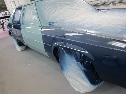 1991 Ford LTD Crown Victoria - A sedan, likely a 1990 Ford Crown Victoria, is partially painted in a workshop.