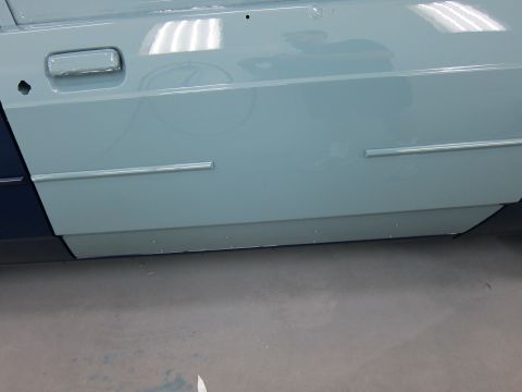 1991 Ford LTD Crown Victoria - Close-up view of a light blue car door, chrome trim and a contrasting dark blue lower panel.