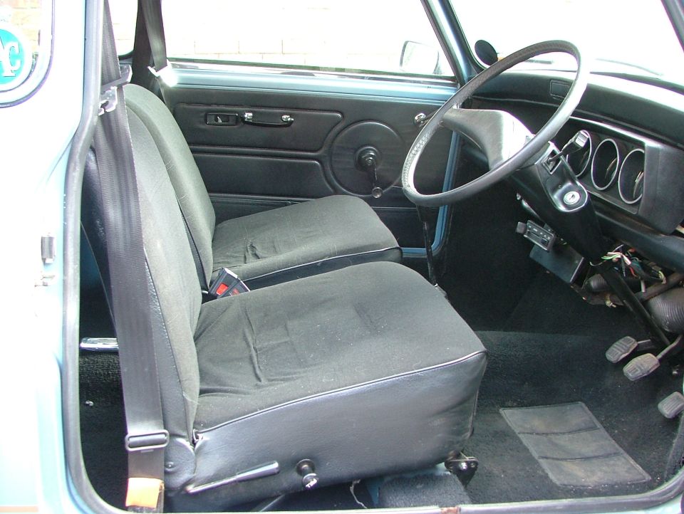 Interior view of a classic car, showing seats, steering wheel, and dashboard