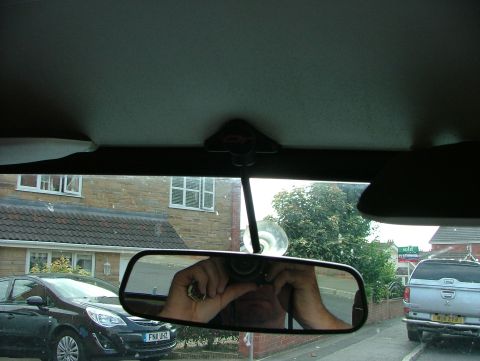 1980 MINI Cooper - View from inside a car, with a reflection in the rearview mirror showing the photographer and two vehicles outside.