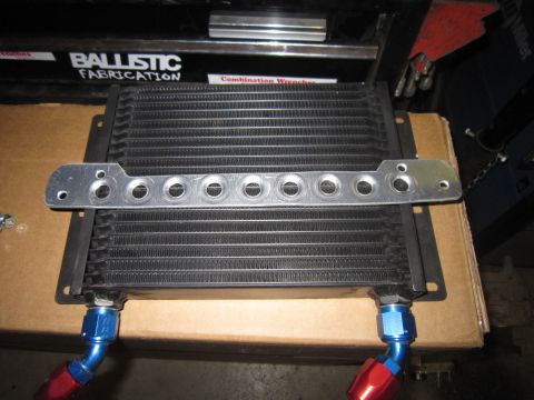 2008 Jeep Wrangler - An aftermarket oil cooler with braided lines and a custom mounting bracket is shown, likely for a vehicle modification.