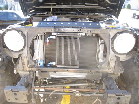 2008 Jeep Wrangler - Front view of a Jeep Wrangler with its hood open, revealing the engine bay and cooling system components.