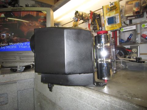 2008 Jeep Wrangler - A chrome and black power steering reservoir sits on a counter in a workshop setting.