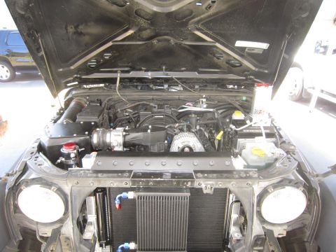 2008 Jeep Wrangler - The engine bay of a Jeep Wrangler shows modifications including an aftermarket radiator and custom engine components.