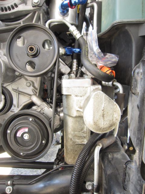 2008 Jeep Wrangler - Close-up view of engine components, including pulleys and hoses, with some aftermarket blue fittings visible.