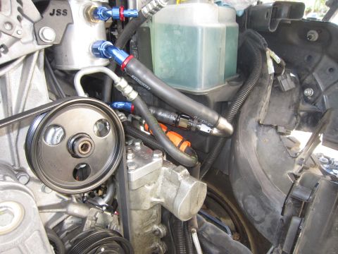2008 Jeep Wrangler - Close-up view of an engine bay, highlighting the power steering pump, an oil catch can labeled JSS, and the fluid reservoir.