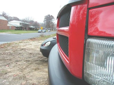 1997 Ford Taurus - A red truck's front end is captured in a close-up shot, with another vehicle partially visible behind it.