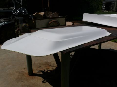 1976 Chevrolet Corvette - A white hood scoop sits on a metal table outdoors.