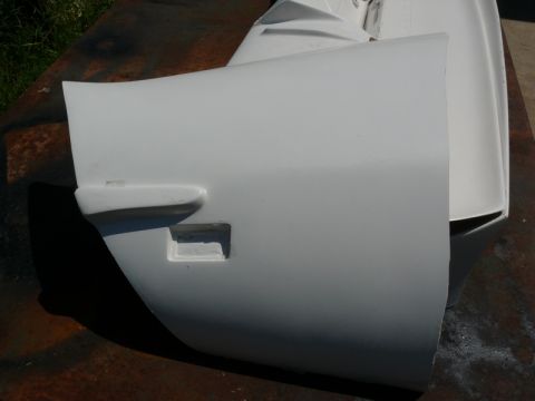 1976 Chevrolet Corvette - A white Corvette door panel is shown, a rectangular cutout and a protruding handle area.