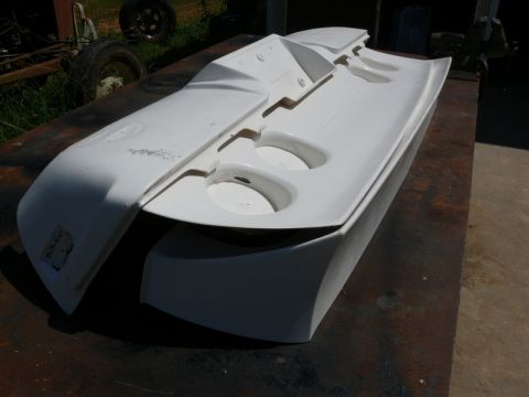 1976 Chevrolet Corvette - A white car body panel with circular cutouts is displayed on a table, with a watermark at the bottom right.