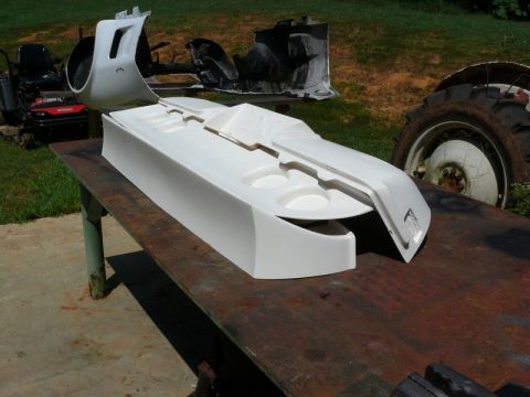 1976 Chevrolet Corvette - A white car interior console with cup holders and a dashboard section sits on a table outdoors.