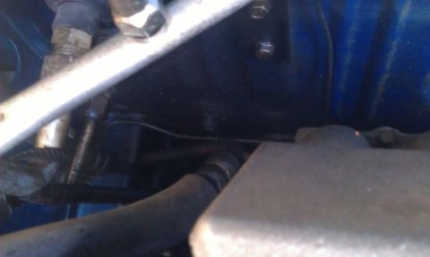 1991 Ford Festiva - Close-up view of engine bay components, including hoses and metal brackets.